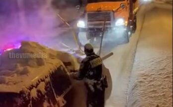 Dashcam footage captures the surreal moment a highway patrol officer is completely engulfed by a wave of snow during a traffic stop
